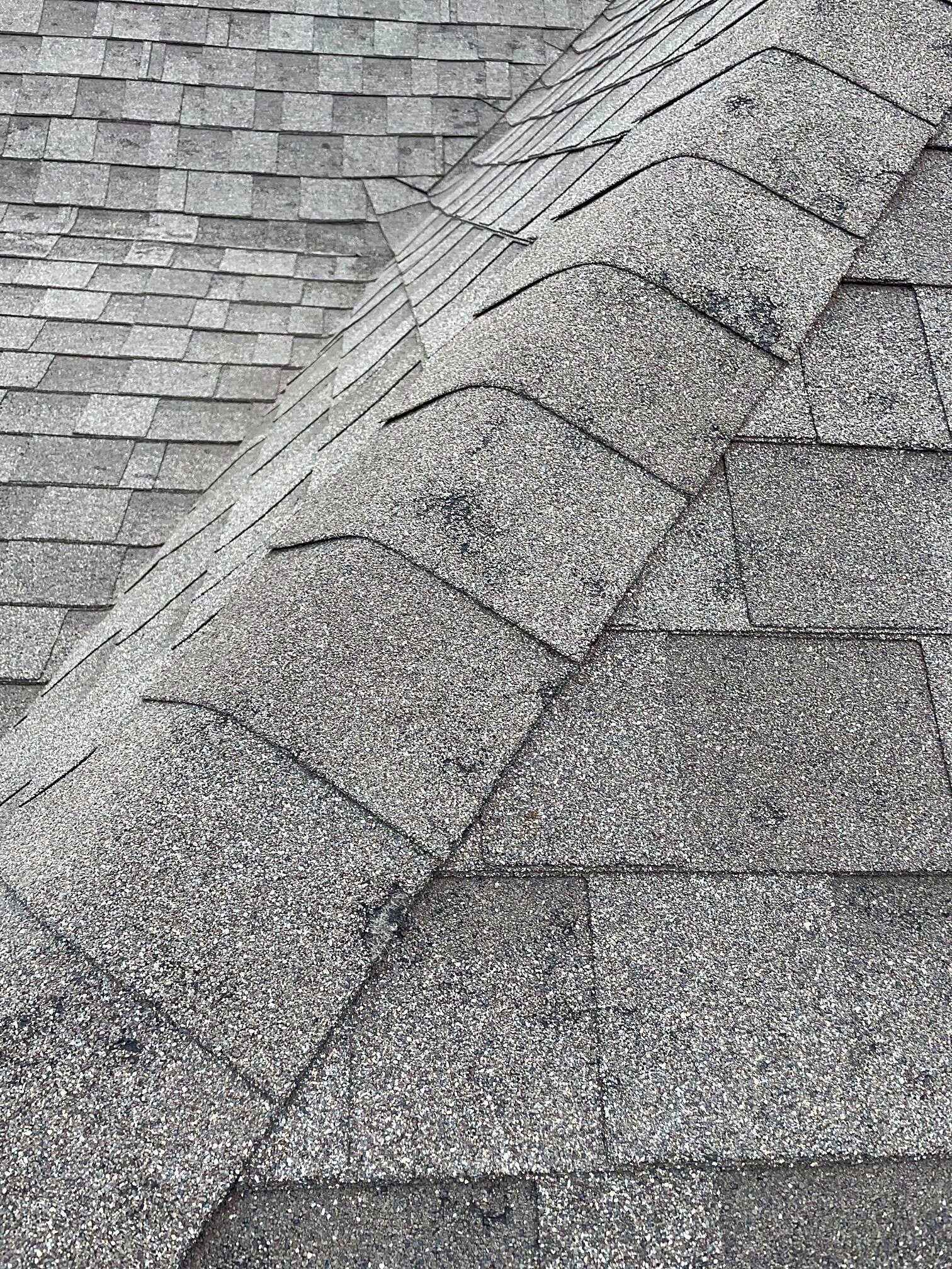 Close view of new ridge cap shingles along a roof ridge